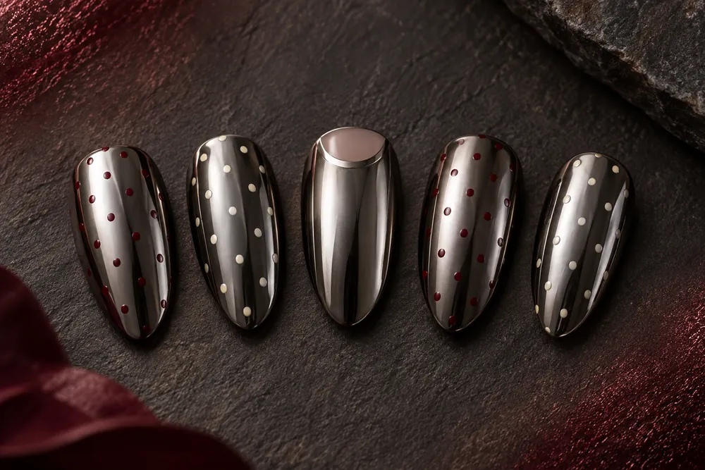 Version 1: molten gunmetal chrome almond nails scattered with oxblood and cream polka dots.
